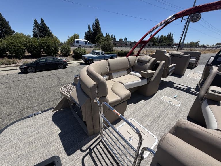 Luxury pontoon boat interior with beige seating and safety railing.