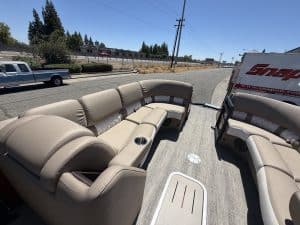 Luxury pontoon boat interior with beige seating and cup holders.