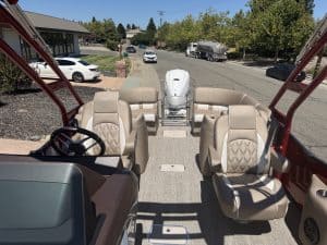View of Bennington 25FT Q pontoon boat interior with beige seats and steering wheel.