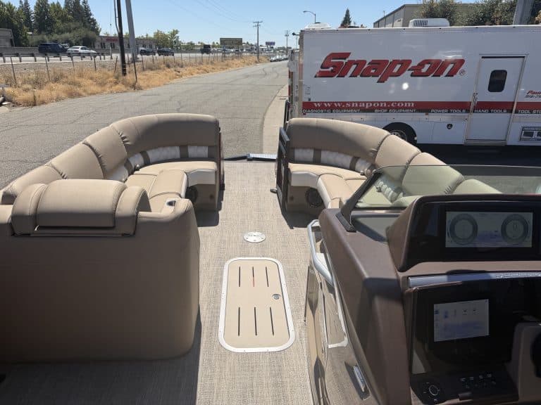 Bennington 25FT Q boat with beige seating and dashboard view.