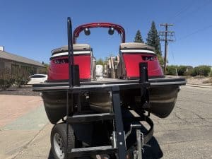 Red and black Bennington 25FT Q pontoon boat on trailer in outdoor setting.
