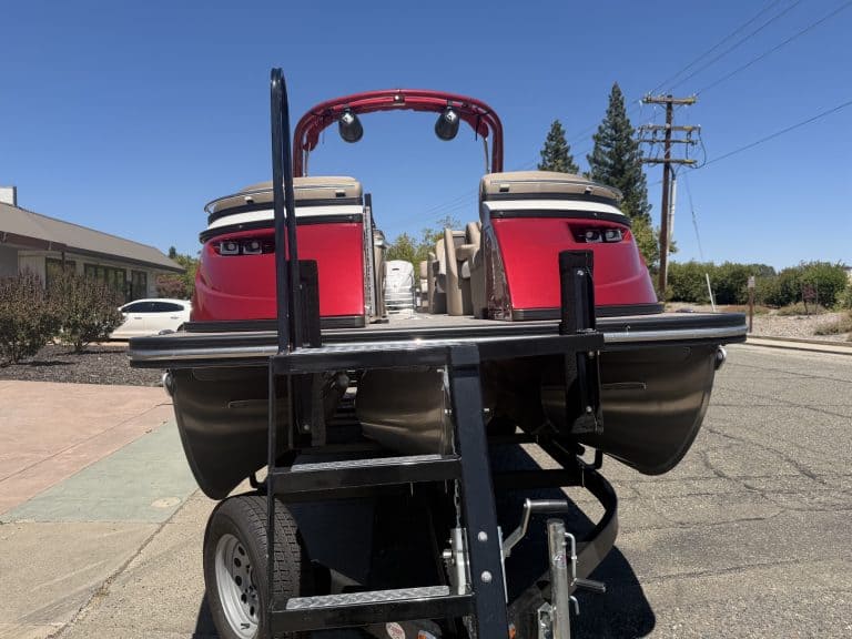 Red and black Bennington 25FT Q pontoon boat on trailer in outdoor setting.