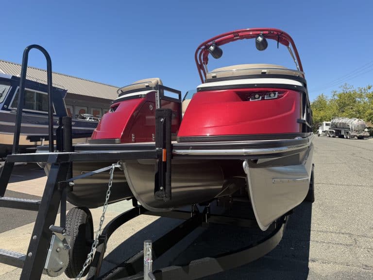 Red and white Bennington 25FT Q pontoon boat on trailer at dealership.