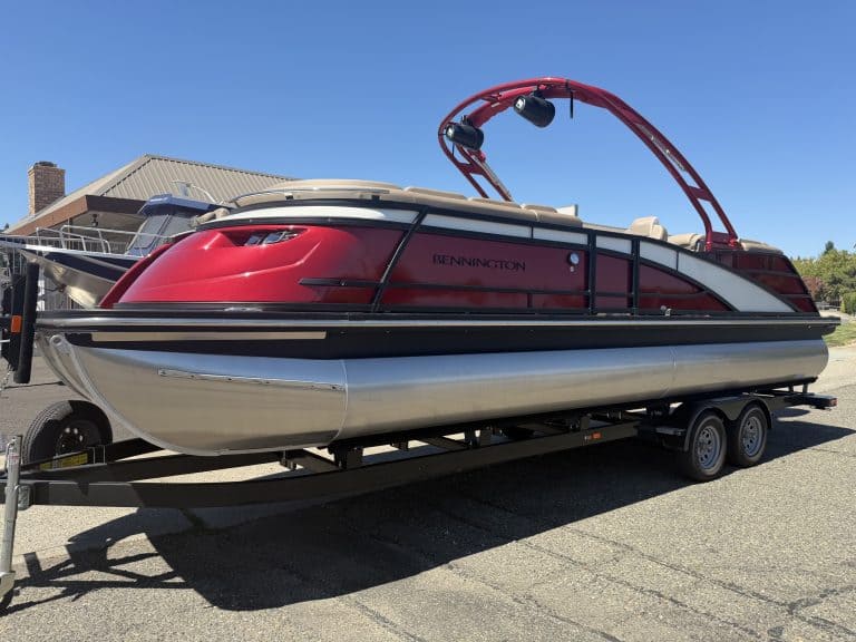 Red and black Bennington pontoon boat on trailer with wakeboard tower.