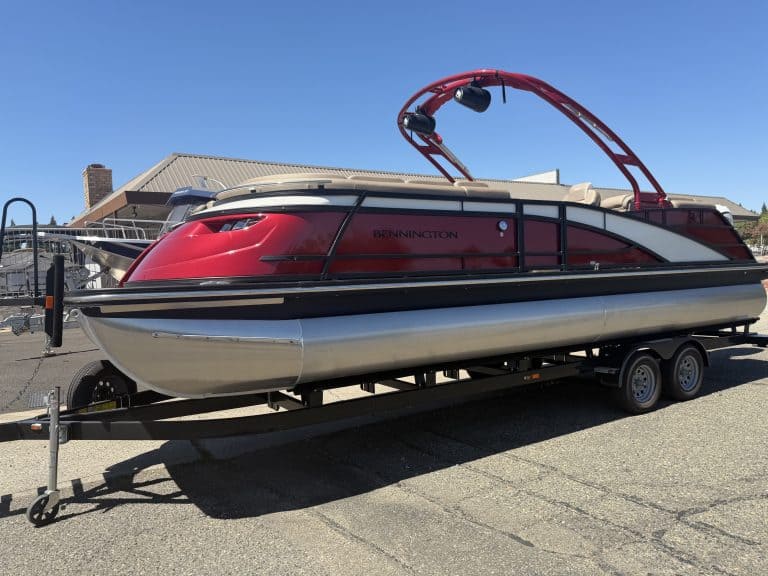 Bennington 25FT Q pontoon boat with red and black design on trailer.