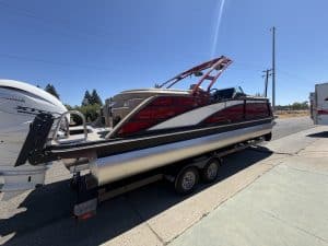 Bennington 25FT Q pontoon boat with red and black design on trailer.