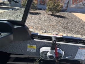 Close-up of boat's interior with steering and controls for fishing.