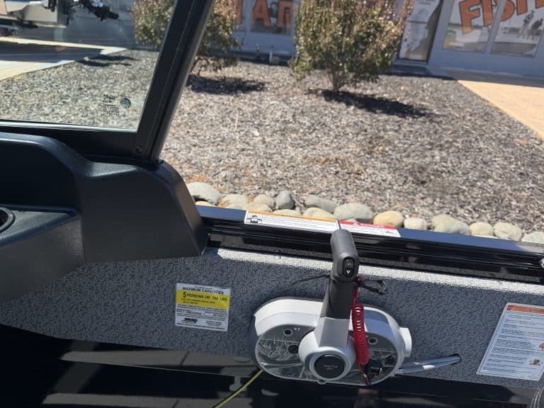 Close-up of boat's interior with steering and controls for fishing.