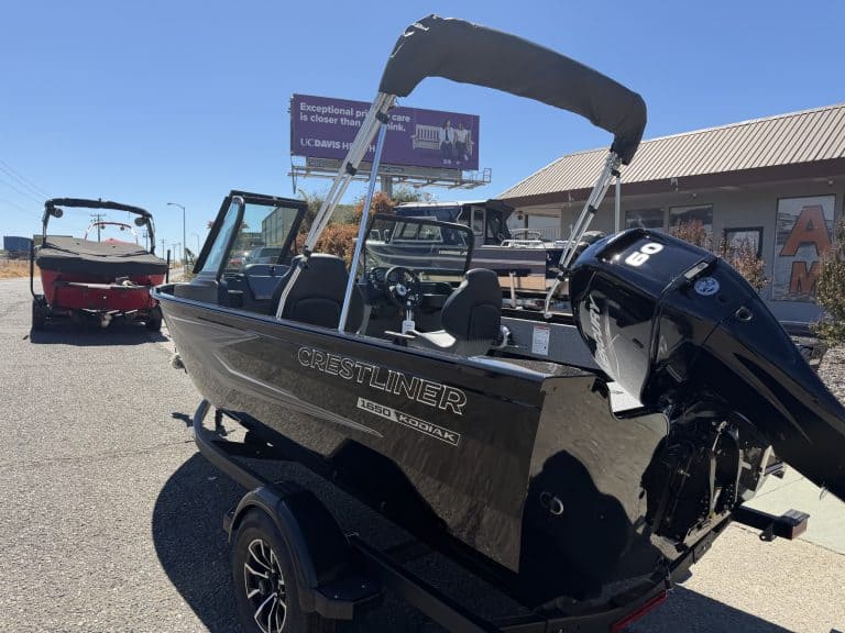 New Crestliner 1650 Kodiak fishing boat with outboard motor and canopy.