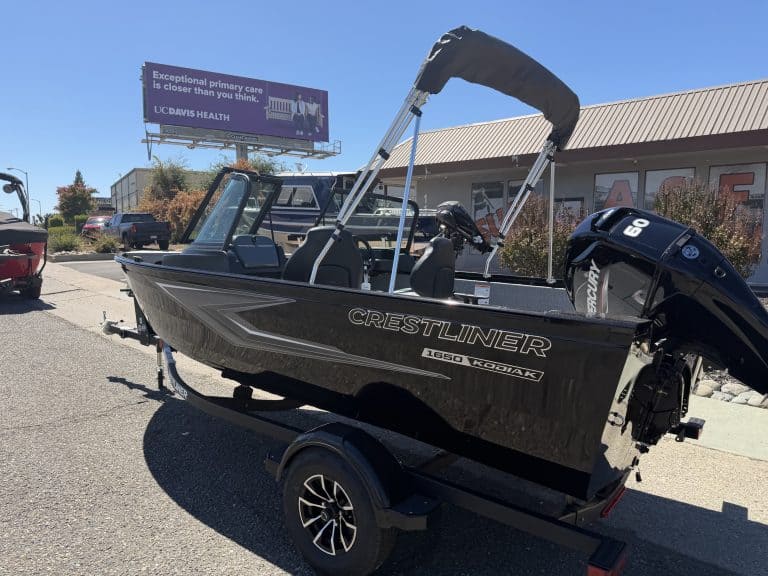 New Crestliner 1650 Kodiak fishing boat on trailer at dealership.