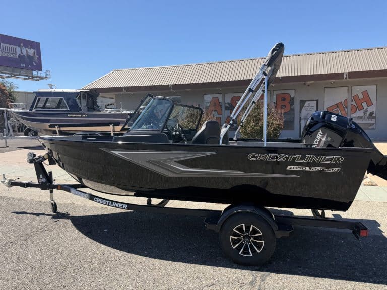 New Crestliner 1650 Kodiak fishing boat on trailer at dealership.