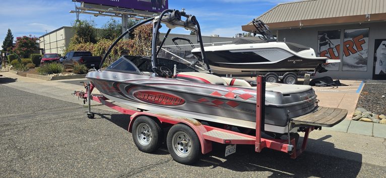 Speedboat on trailer at ASFB Marine with clear blue sky background.