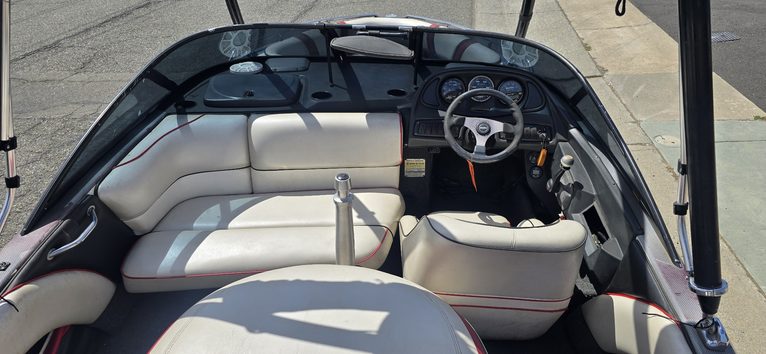 Luxury boat cockpit with steering wheel and dashboard.