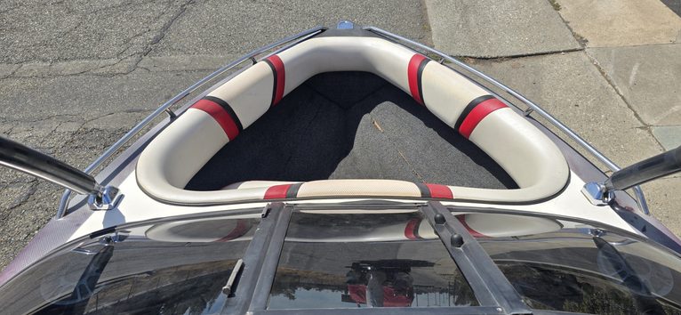 Close-up of boat seating area with cushioned seats and safety rails.