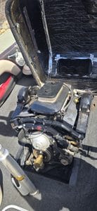 Marine boat engine with black cover and mechanical components.