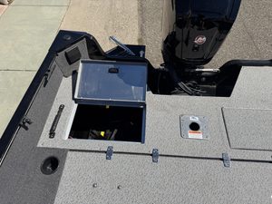 Boat deck with storage compartments and Mercury outboard engine.