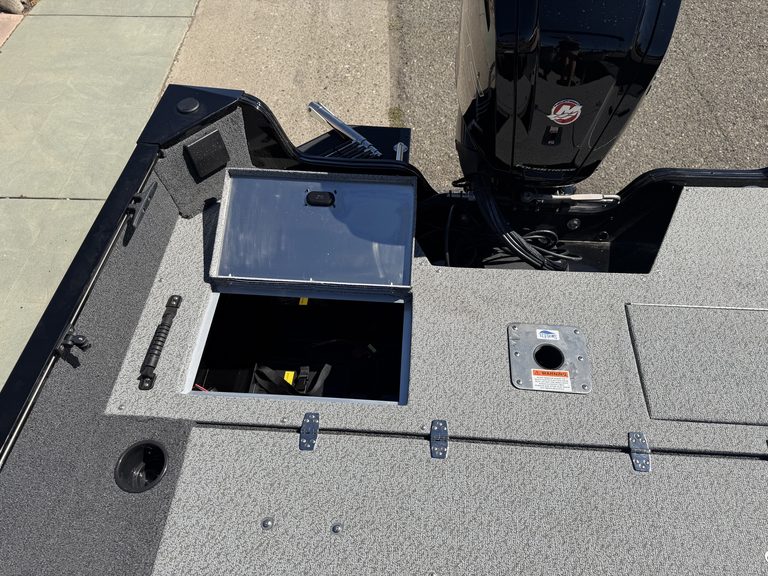 Boat deck with storage compartments and Mercury outboard engine.