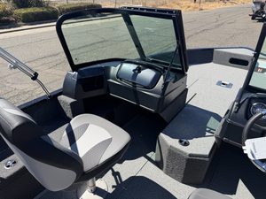 Boat cockpit with steering and control panel in outdoor setting.