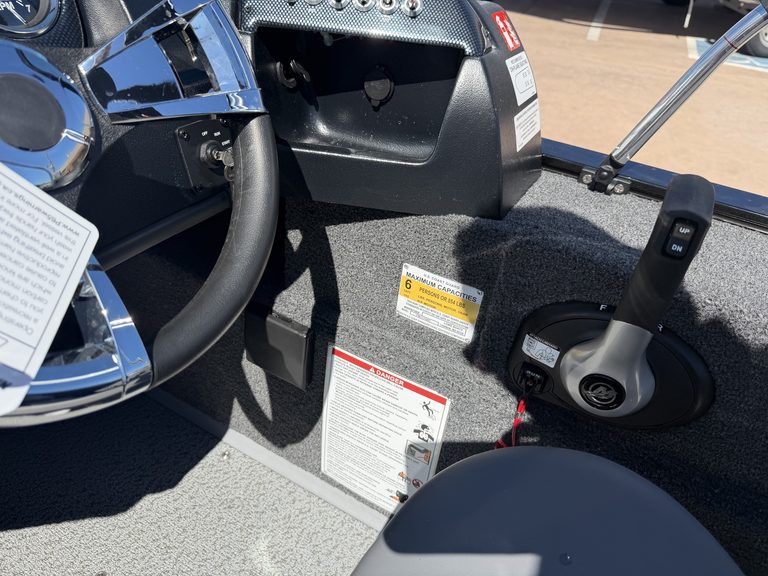 Boat interior with steering wheel and control panel at ASFB Marine.
