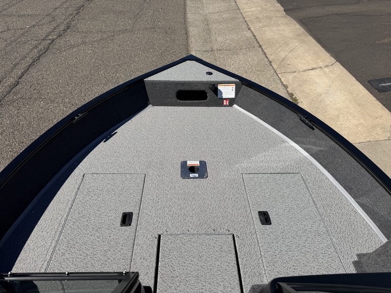 Close-up of bass boat deck with storage compartments and non-slip surface.