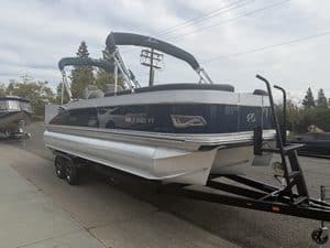 Luxury Avalon Catalina pontoon boat on trailer at dealership lot.