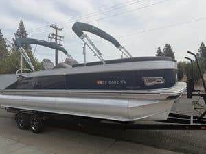 Luxury Avalon Catalina pontoon boat on trailer with Bimini top and sleek design.