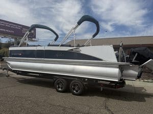 Luxury Avalon Catalina pontoon boat on trailer with outboard motor.