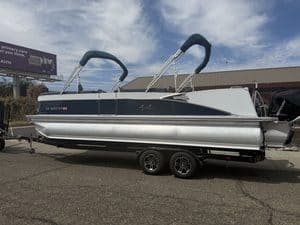 Luxury Avalon Catalina pontoon boat on trailer with outboard motor.