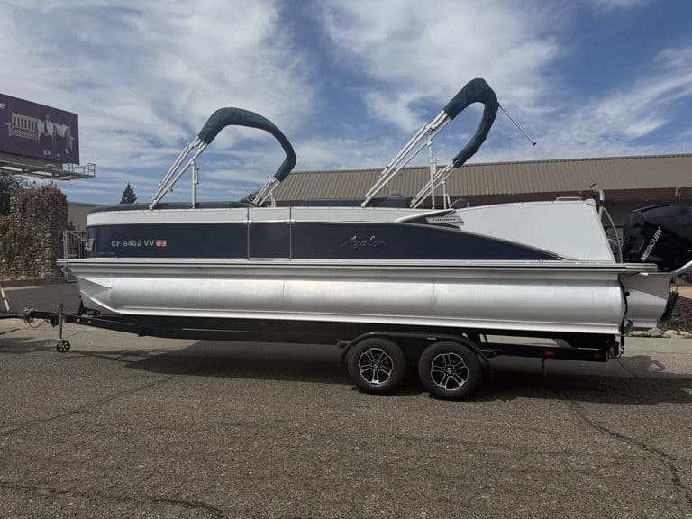Luxury Avalon Catalina pontoon boat on trailer with outboard motor.