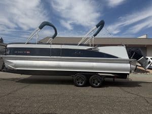Luxury Avalon Catalina pontoon boat on trailer with outboard motor.