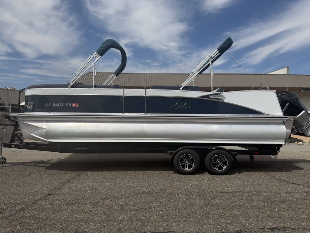 Luxury Avalon Catalina pontoon boat on trailer with blue sky background.