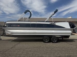 Luxury Avalon Catalina pontoon boat on trailer with blue sky background.