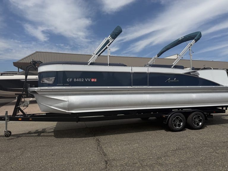 Luxury Avalon Catalina pontoon boat on trailer at marina.