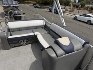 Pontoon boat interior with white and navy seating for leisure boating.