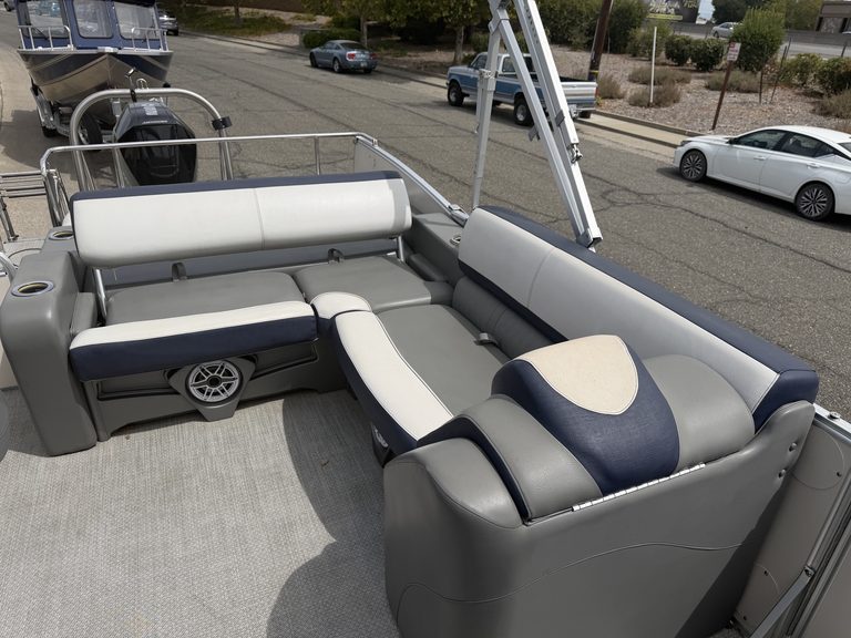 Pontoon boat interior with white and navy seating for leisure boating.