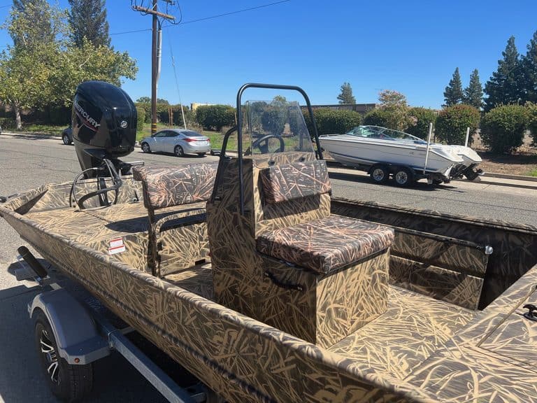 Camouflage boat with outboard motor on trailer at ASFB Marine.