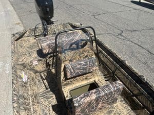 Camo-patterned Lowe RX 1860 jet boat with outboard motor and steering console.