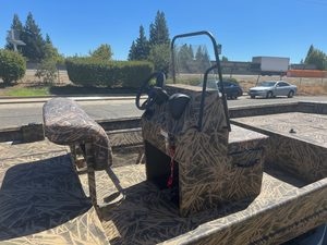 Aluminum fishing boat with camouflage pattern and steering console.