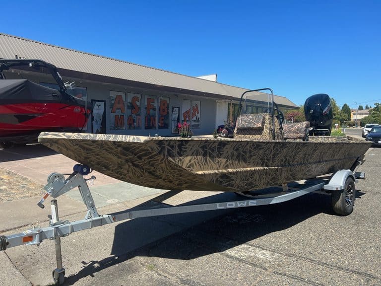 Camouflage Lowe RX 1860 jet boat with outboard motor on trailer.