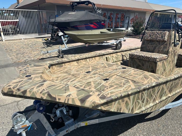 Camouflage utility boat with seating and trailer for outdoor use.