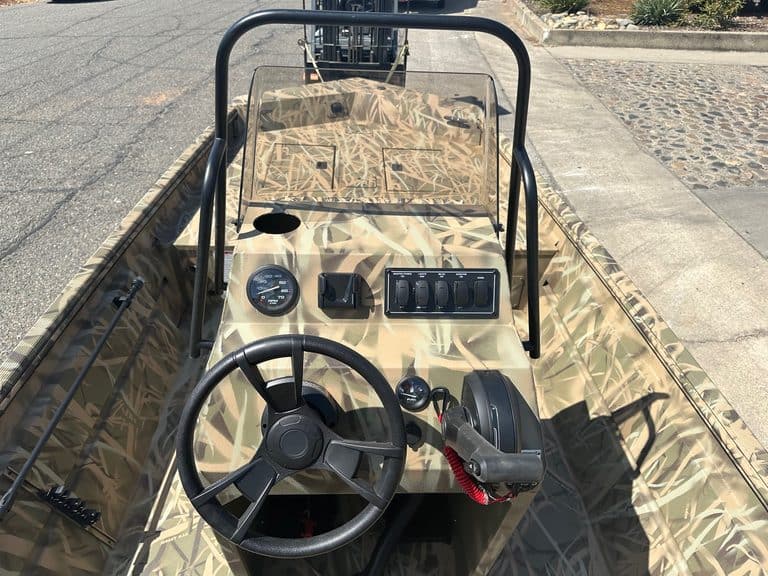 Close-up of boat dashboard with steering wheel and controls.