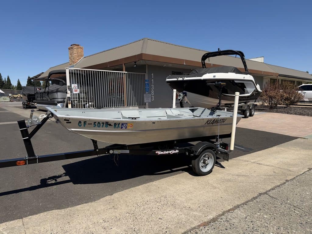 Small aluminum boat with motor on trailer at ASFB Marine.