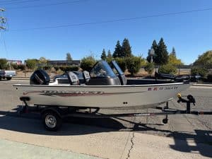 Fishing boat on trailer with Mercury 60HP engine, outdoor setting.