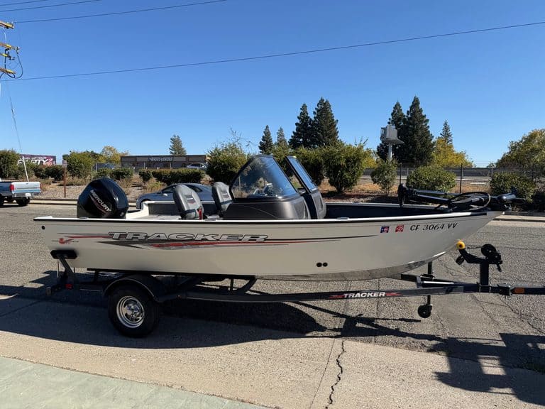 Fishing boat on trailer with Mercury 60HP engine, outdoor setting.