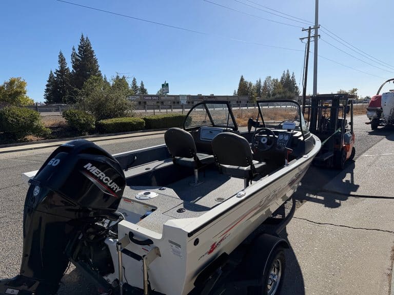 Fishing boat with Mercury 60HP outboard motor on trailer.