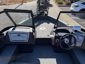 Boat dashboard with steering wheel and controls for fishing or leisure.