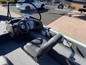 Boat cockpit with steering wheel, controls, and Mercury 60HP engine.