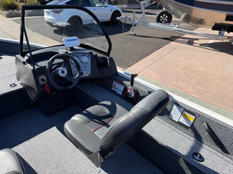 Boat cockpit with steering wheel, controls, and Mercury 60HP engine.