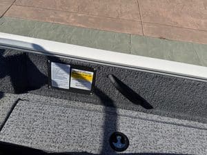 Close-up of boat interior with safety labels and flooring details.