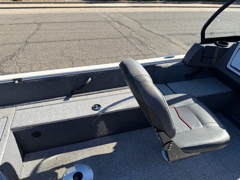 Boat interior with seat and storage for fishing or leisure.